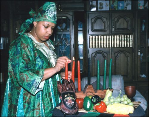 A woman lights kinara candles